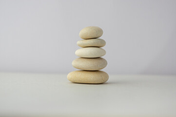 Stone cairn on white background, five stone tower, simple poise stones, simplicity harmony and balance