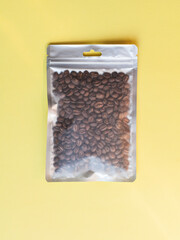Blank craft plastic pouch mock up with coffee beans inside, transparent pack on studio background with shadow, mylar bag isolated for coffee product