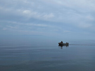 Fisherman in Rowboat on Tranquil Waters