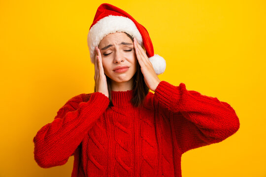 Funny santa mood rescue red sweater girl taps temples during christmas chaos on a bright yellow backdrop smiling through stress