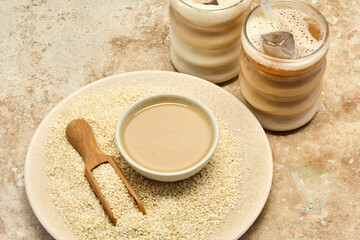 Sesame Tahini Latte Delight. Creamy sesame paste and iced tahini lattes on rustic travertine surface.