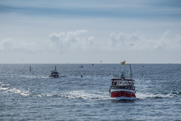 Naklejka premium Fish boat sailing back to the harbor in Atlantic ocean, Bretagne France