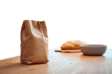 close-up of a brown paper bag standing on a wooden table with blurred bread and a bowl in the background, isolated on a transparent background
