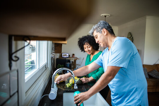 Middle aged couple preparing food in kitchen