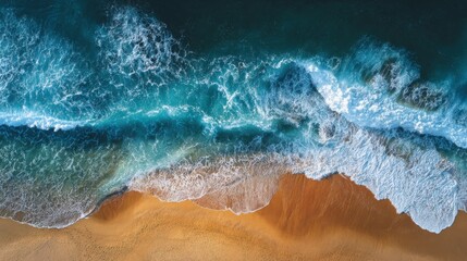 Top aerial view of golden sandy beach meeting deep blue ocean waves. Seaside vacation and travel concept.