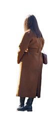 Femme vue de dos portant un long manteau marron, sac à bandoulière en cuir, bottines noires, cheveux bruns mi-longs largement éclairés par un soleil rasant, position debout les pieds croisés