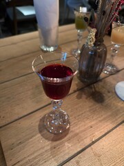 Elegant Glass of Red Liqueur on Wooden Table