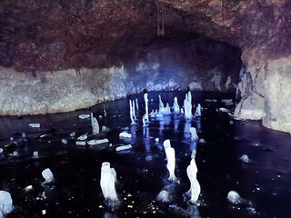 A cave with a stream of water and ice in it