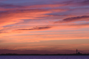 Golden sunset over a peaceful New England beach with gentle waves and serene horizon.