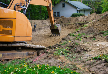 A backhoe completing the digging of a drainfield  excavation for a home septic system