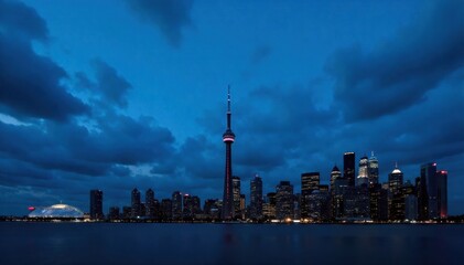 Obraz premium Iconic CN Tower silhouette against a moody Toronto skyline at twilight, Ontario The silhouette of the CN Tower and the Toronto skyline during twilight. Deep blue and purple hues dominate the sky, with