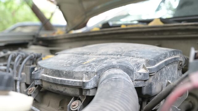Close-up of a car engine starting with the sound of the starter and revving RPMs, showing engine components under the open hood