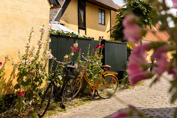 yellow A frame homes and small streets in dragor village copenhagen with bicycles in front, bike culture, 