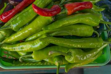 Colorful peppers in market baskets. Assorted fresh vegetables including vibrant peppers displayed in woven baskets at local market.