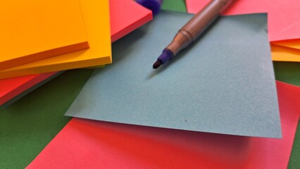 Colorful Sticky Notes and Marker on Green Surface