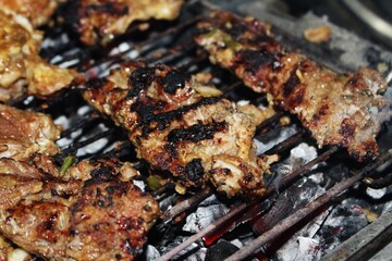 Marinated meat grilling over glowing charcoal&mdash;symbolizing texture, intensity, and the primal rhythm of outdoor fire cooking
