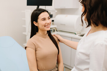 Fototapeta premium Gynecologist consulting patient before ultrasound examination. Gynecologist reassuring woman after gynecological exam. Post-exam consultation with gynecologist.