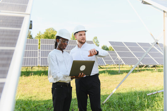 Engineers inspecting solar panels at renewable energy plant
