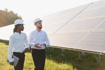 Engineers inspecting solar panels at renewable energy farm