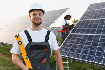Fototapeta premium Solar energy technicians working at a solar farm