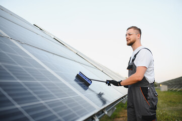 Technician cleaning solar panel increasing renewable energy efficiency