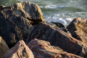 Textured Seashore Rocks Against a Blurred Ocean Backdrop at Golden Hour