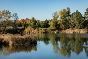 Widok na piękne, spokojne jezioro jesienną porą z kolorowymi drzewami