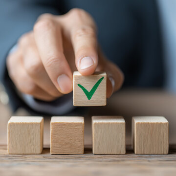School leader placing cube with green checkmark representing academic integrity, policy adherence, and quality assurance in administrative office- 

