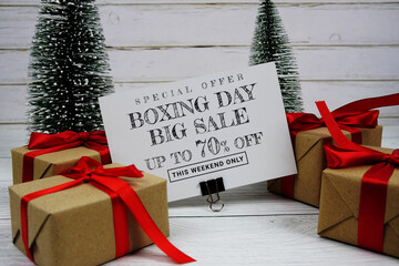 Festive display with small decorative Christmas trees and gift box present with "Special Offer Boxing Day Big Sale up to 70% off, Promotion Holiday Sale Event