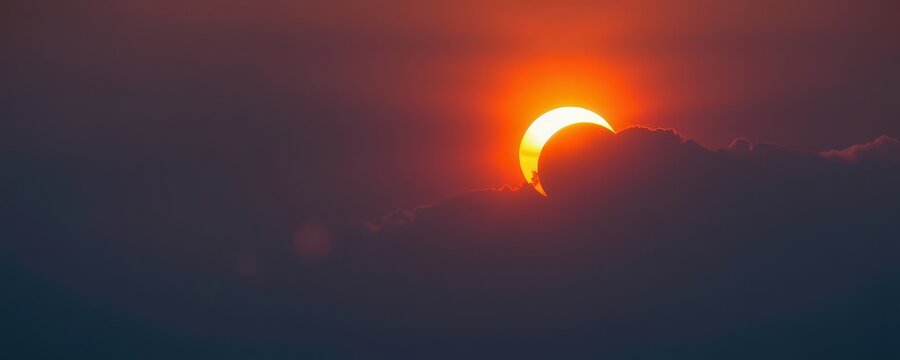 Rare celestial event as the sun dips below the horizon, casting a fiery glow through a partial solar eclipse, rare, solar eclipse, atmospheric