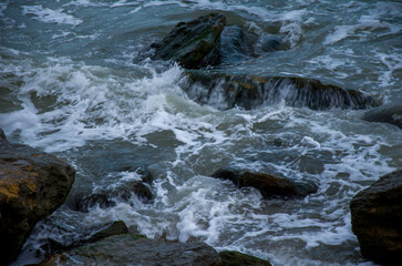Dynamic Sea Waves Crashing Over Dark Coastal Rocks with Intense White Foam