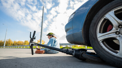 A Caucasian woman on a scooter after being hit by a car.