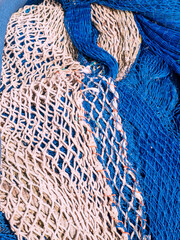 Close up of a pile of different types and colors of fishing nets or trawl nets waiting to be used in the Mediterranean Sea.