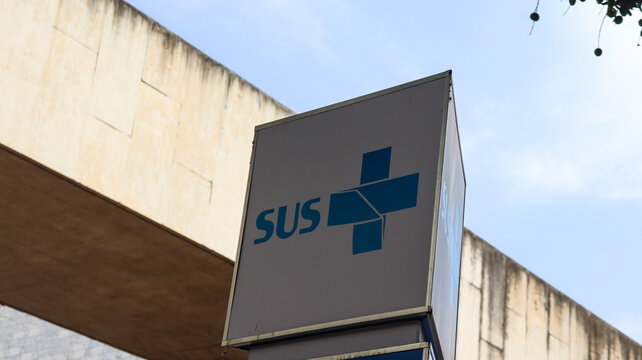 Totem com logo do SUS posicionado em ambiente p&uacute;blico de Bras&iacute;lia, DF, simboliza acesso universal &agrave; sa&uacute;de e estrutura institucional. Bras&iacute;lia DF em 20 out 2025