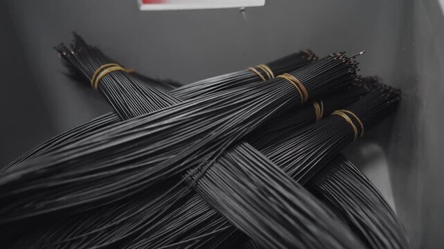 Detailed close-up of multiple tightly bound bundles of black electrical cables, ready for usage or further production