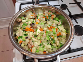 Vegetable stew is cooked on gas stove. Ragout is cooked in metal pan