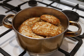 Cooking, stewing meat. Meat cutlets are stewed in saucepan. Meat patties