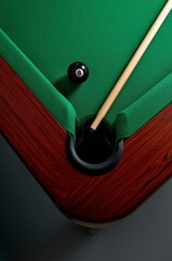 A captivating high-angle view showcases a vibrant green billiards table, highlighting a pivotal moment in a game. The sleek black 8-ball rests tantalizingly close to the dark pocket, while a polished 