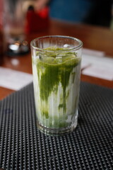Iced matcha latte in a clear glass offers a refreshing and visually appealing beverage, ideal for a cafe menu or healthy lifestyle promotion