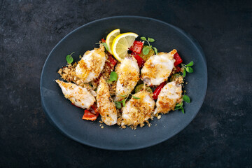 Traditional barbecue Greek calamari with herb and lemon as top view on a plate