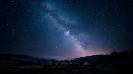 Fototapeta premium The majestic Milky Way galaxy illuminates a starry night sky above a remote mountain campsite with tents