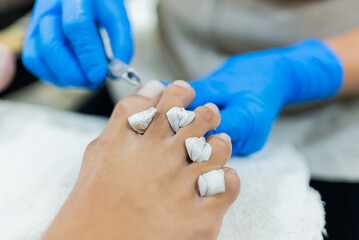 Men's feet receiving a pedicure at a beauty salon specializing in foot care