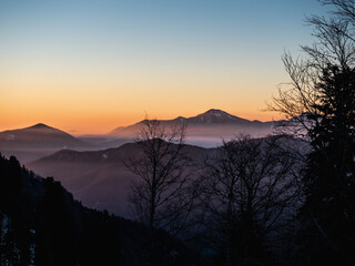 Winter mountain landscape, snowy peaks on sunset with fog
