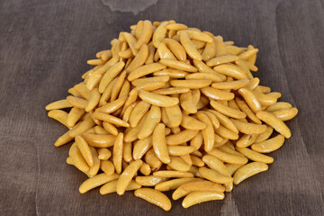 Pile of Japanese rice crackers kaki no tane on dark wooden table.