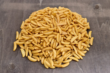 Pile of Japanese rice crackers kaki no tane on dark wooden table.