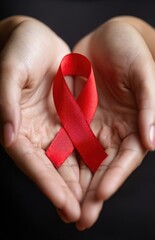 Hands holding red ribbon for aids hiv awareness