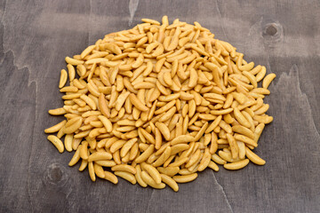 Pile of Japanese rice crackers kaki no tane on dark wooden table.