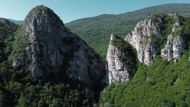 Close aerial view of dramatic rocky cliffs in Jerma Canyon mountains, Serbia country, surrounded by dense forest. Horizontal 4k footage.