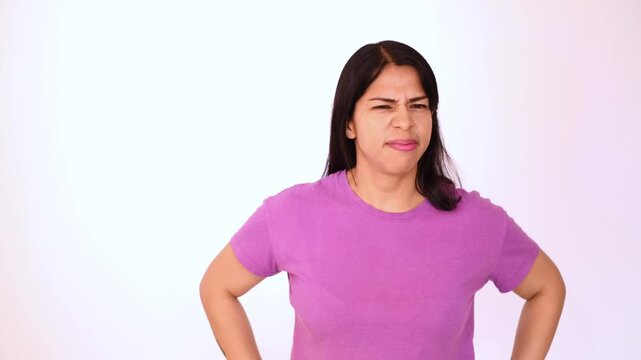 Woman wearing a purple T-shirt isolated on a white background with an expression of disgust, anger, or disgust