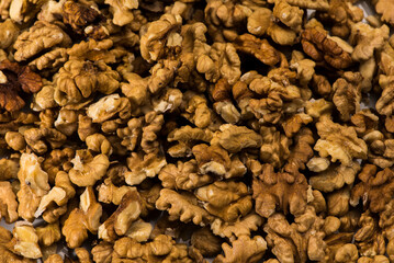 Nueces peladas y enteras esparcidas llenando plano.